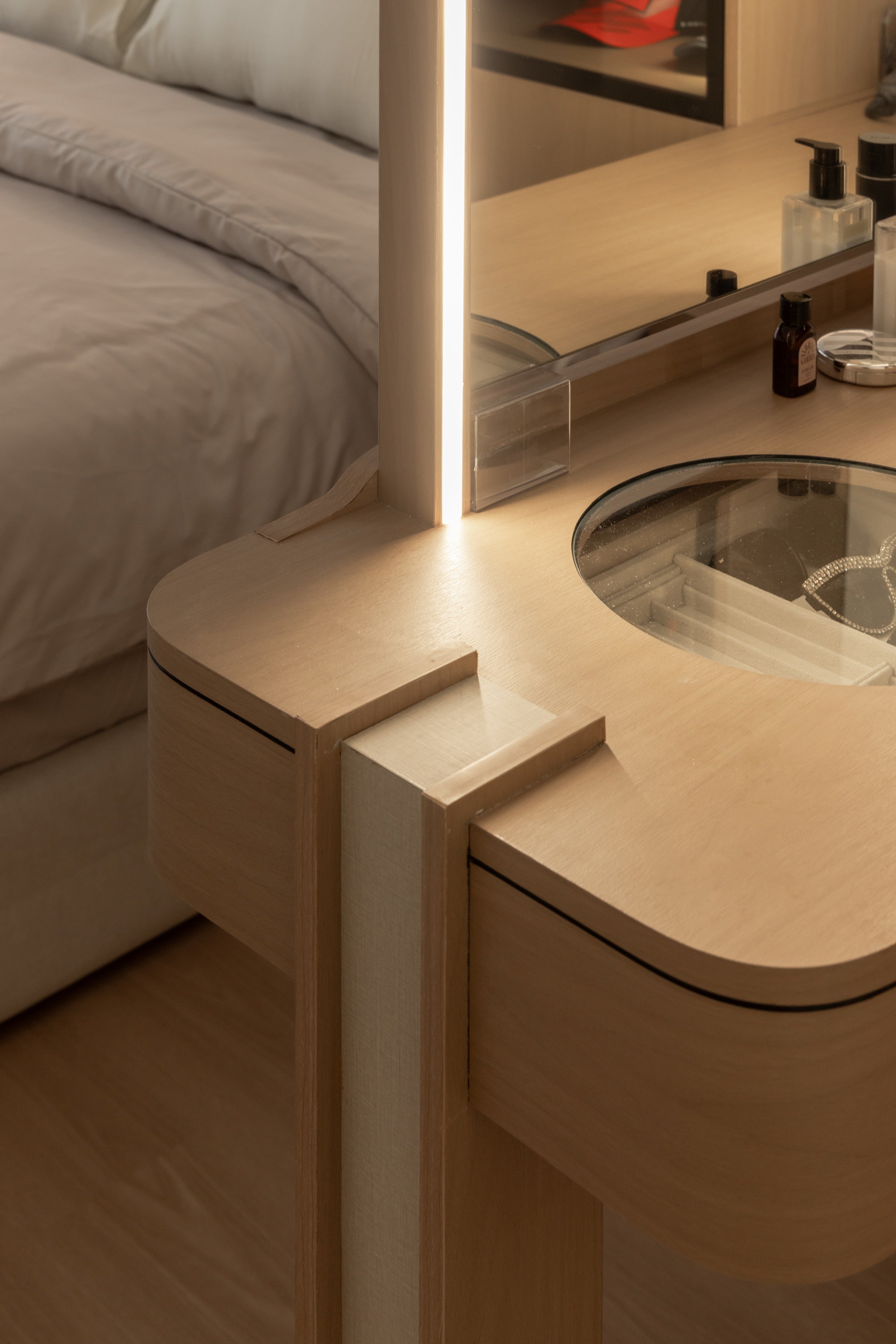 Dressing table detail with lit mirror and glass-top jewellery drawer