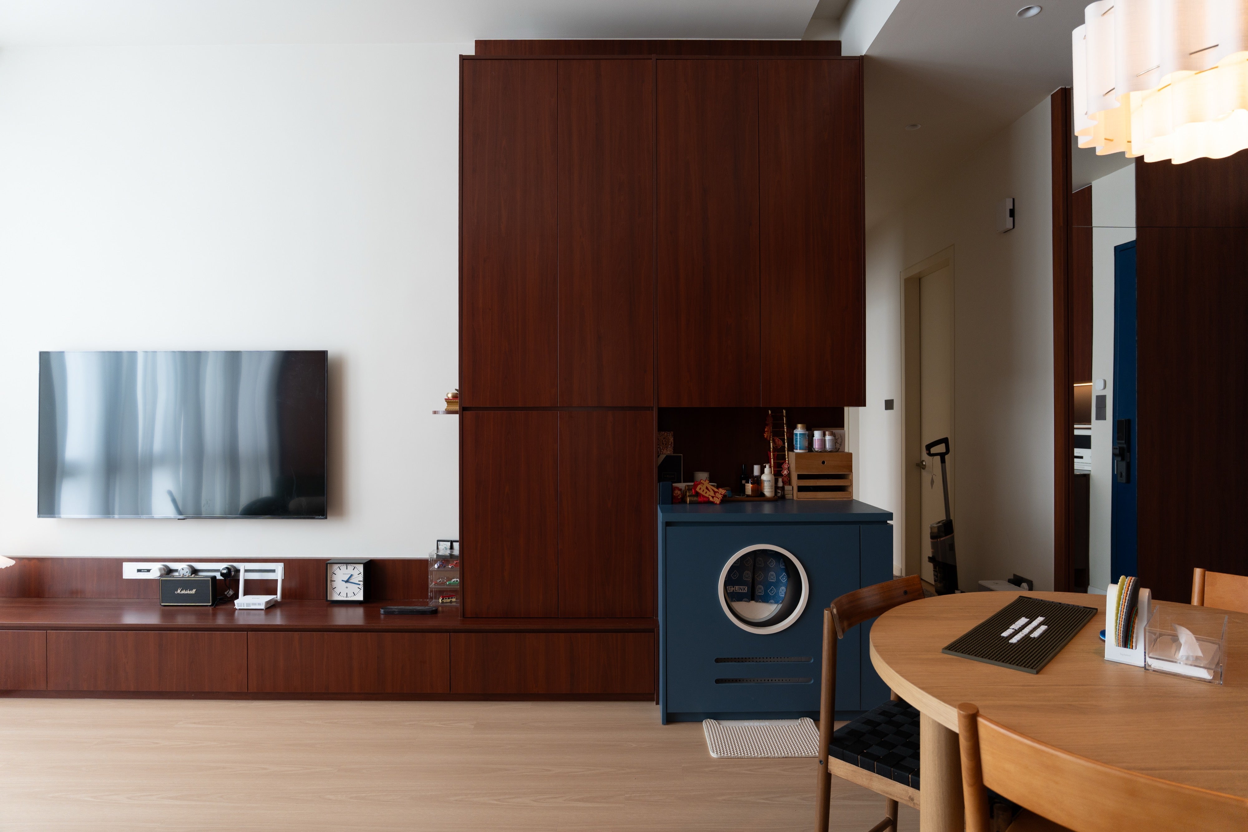 TV console, cherry storage wall and navy cat litter cabinet in a condo at The Maple OUG