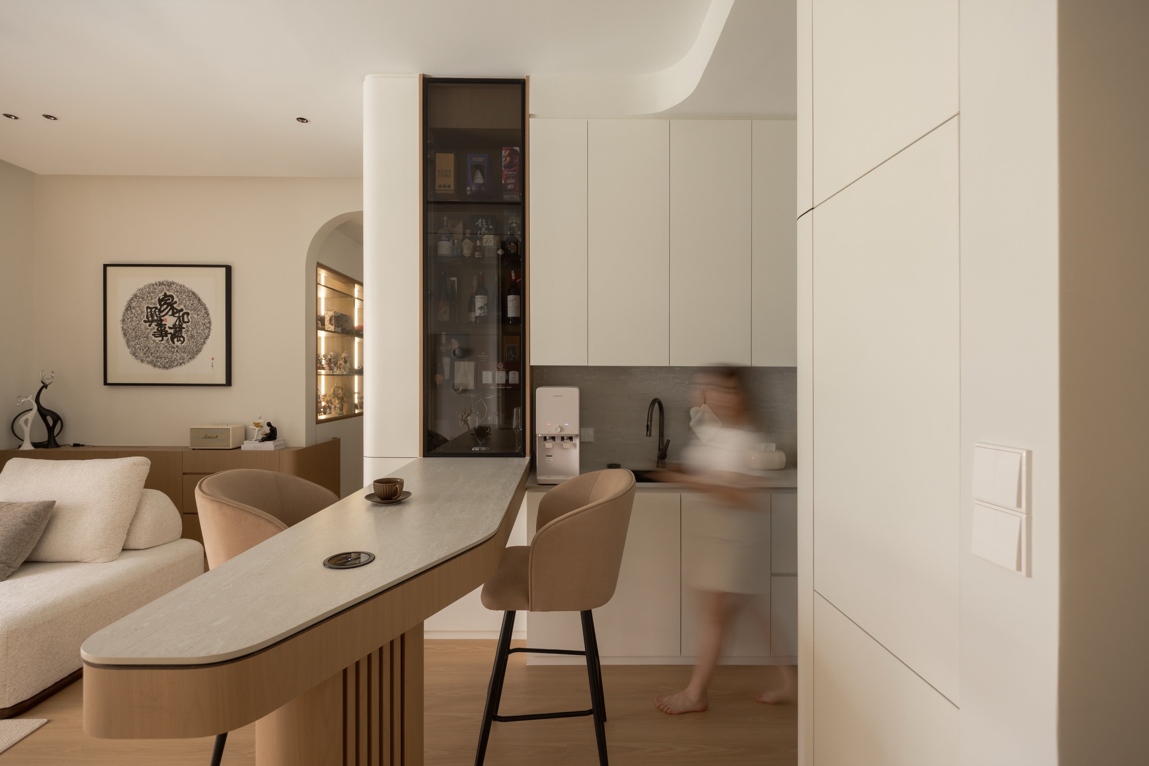 Curved oak bar counter with wine display cabinet and kitchen