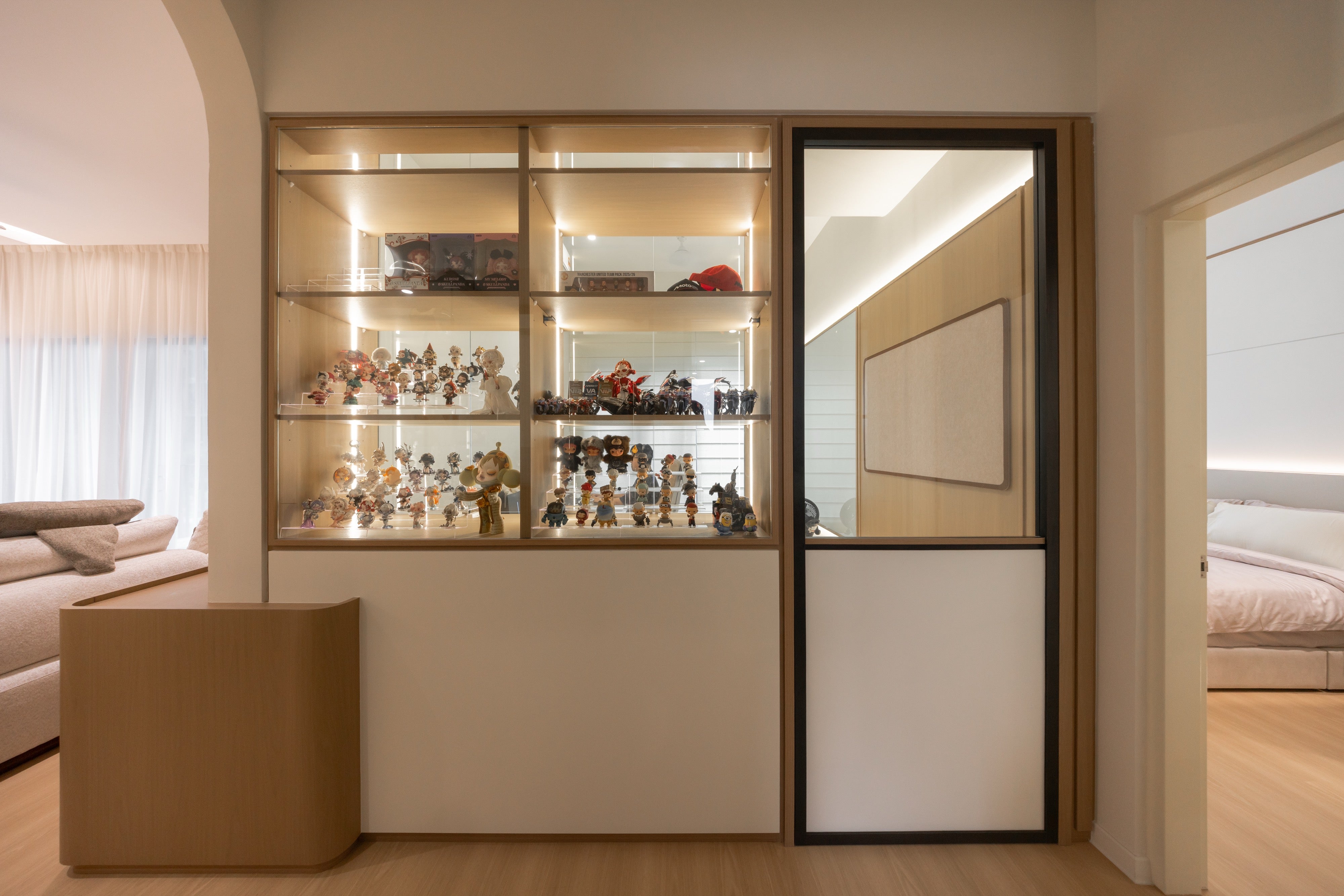 Lit display cabinet for figure collection beside the study door