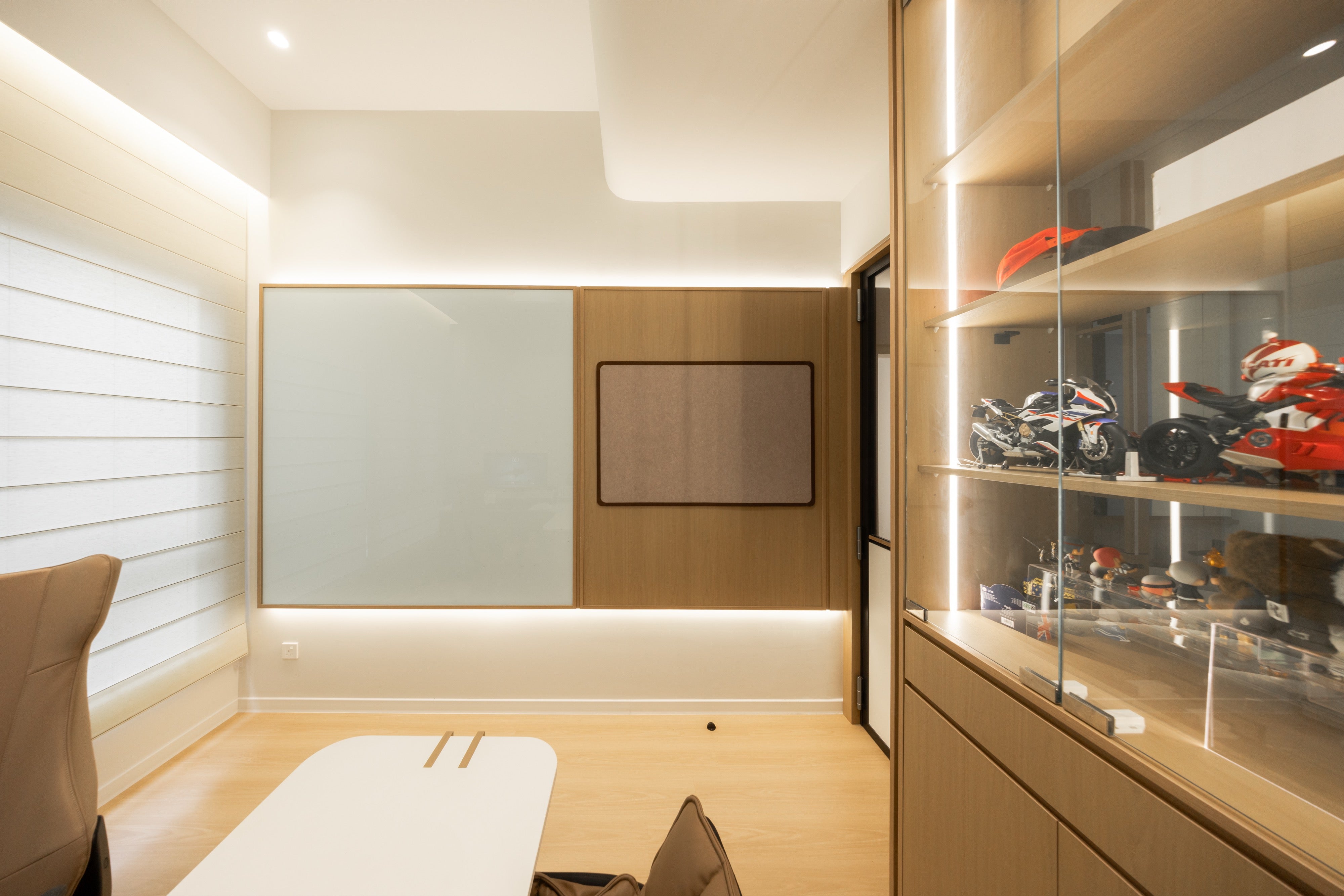 Study room with built-in desk and lit display cabinet