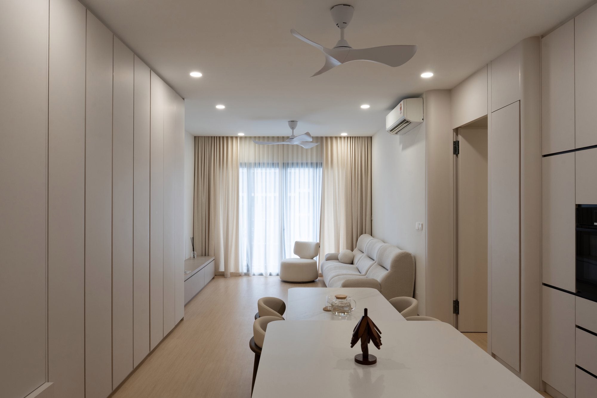 Living, dining and kitchen of a cream minimalist condo interior design in Kuala Lumpur