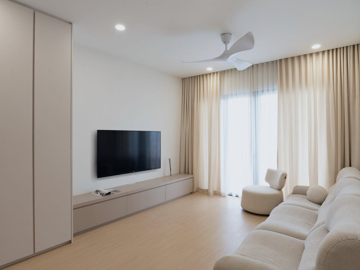 Cream living room with curved sofa and sheer curtains