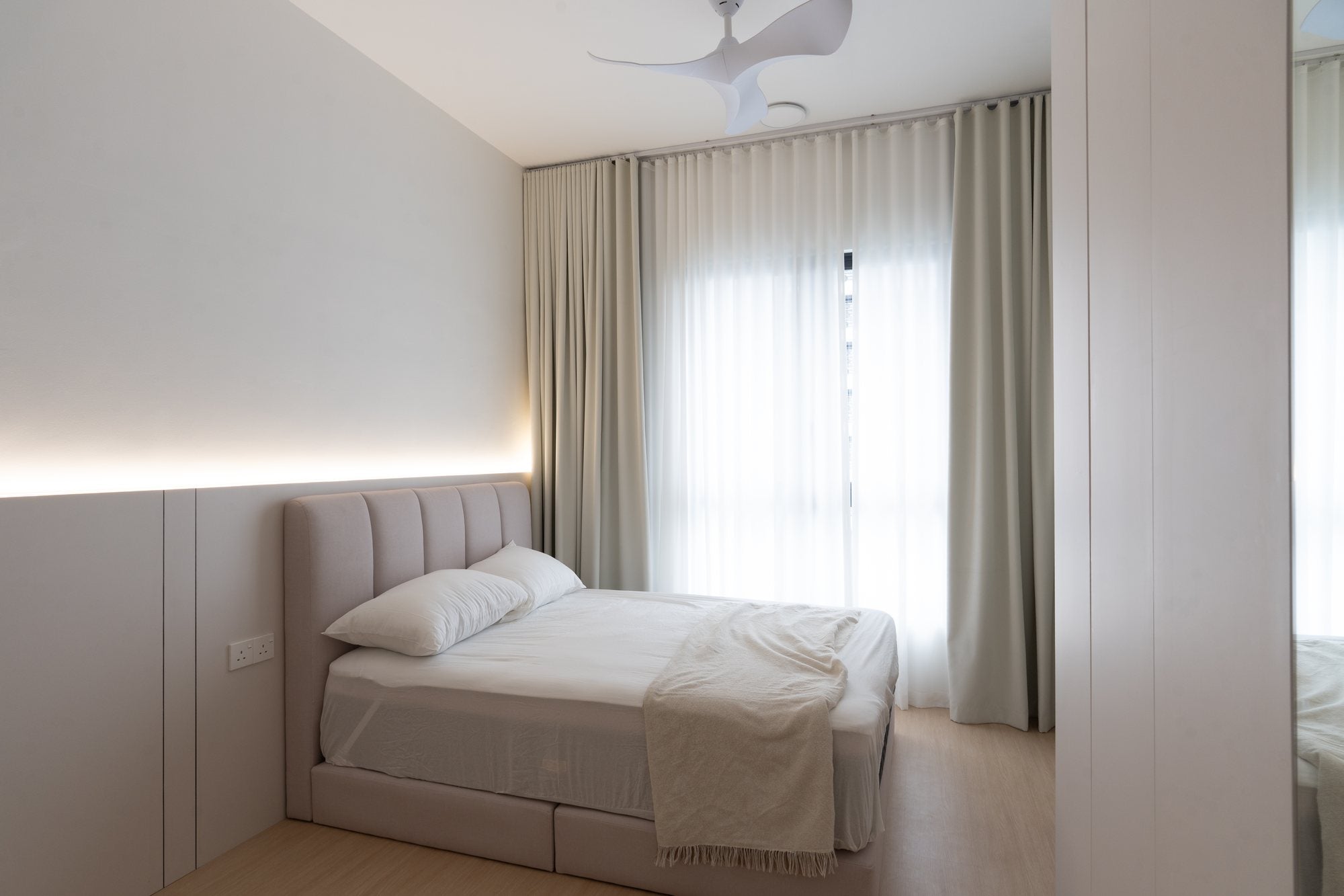 Bedroom with padded bedhead panel and cove lighting