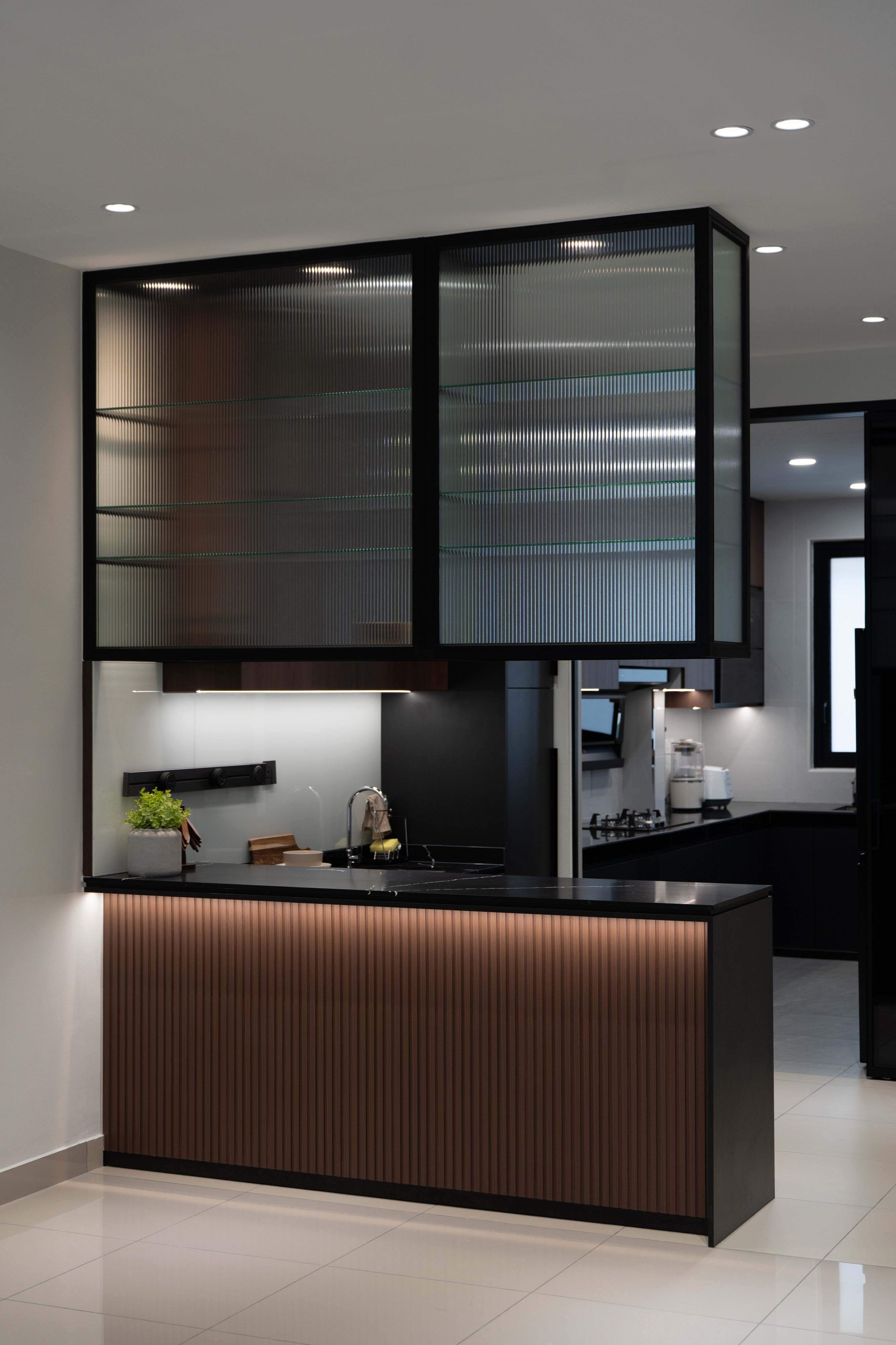 Dry kitchen with fluted glass overhead cabinet and fluted walnut island at Dahlia Bukit Puchong