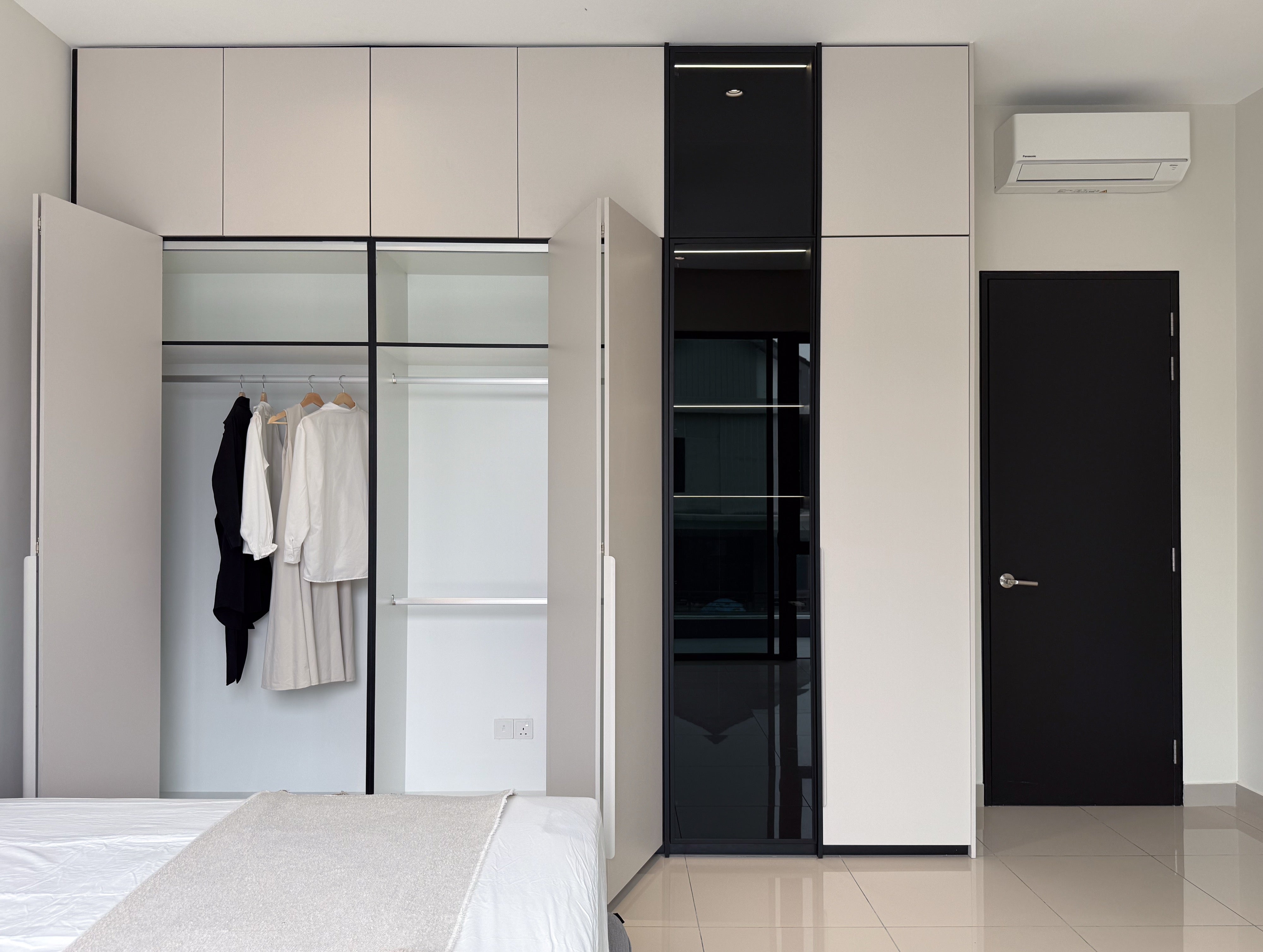 Master bedroom full-height wardrobe with black glass display column, doors open