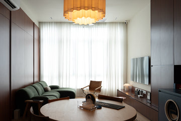 Living room with full-height cherry laminate panel wall, floating TV console and round dining table, The Maple OUG